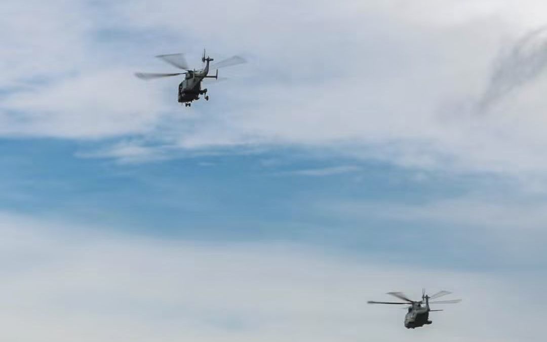 Two Royal Navy helicopters flying over the course